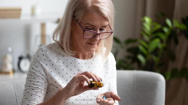 Una mujer toma un suplemento durante la menopausia.