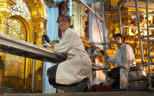 Carmen Martín y Aiora Elkoro trabajan en la restauración del retablo mayor de la iglesia del convento de Santa Clara.