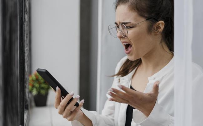 Una mujer con un teléfono en la mano. Una mujer con un teléfono en la mano.