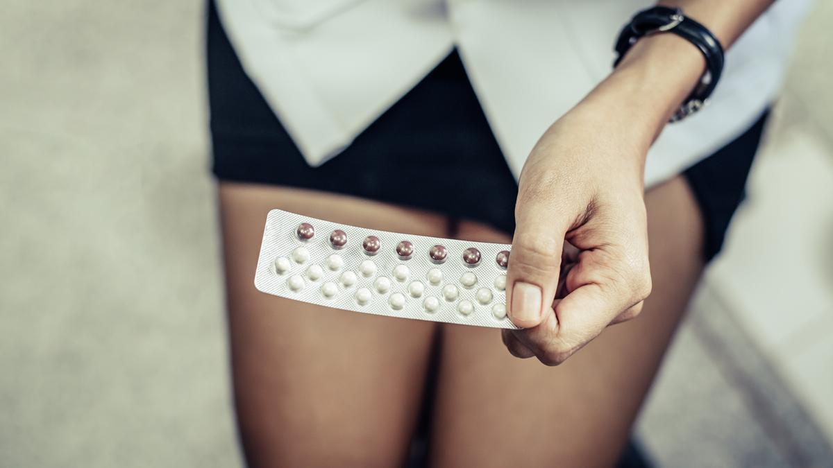 Una mujer sostiene una caja de pastillas.