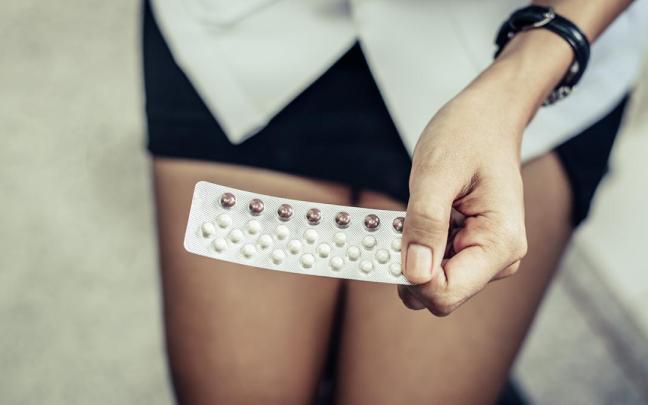 Una mujer sostiene una caja de pastillas.