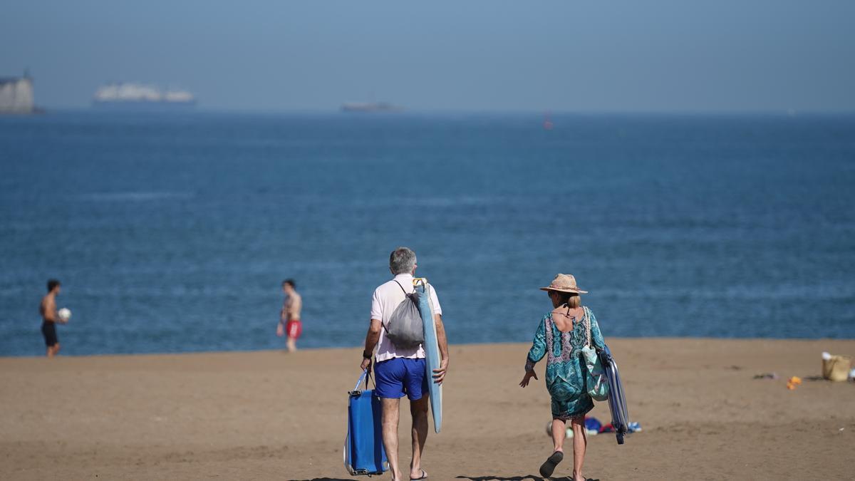 Varias personas pasean por la Playa de Ereaga en Getxo.