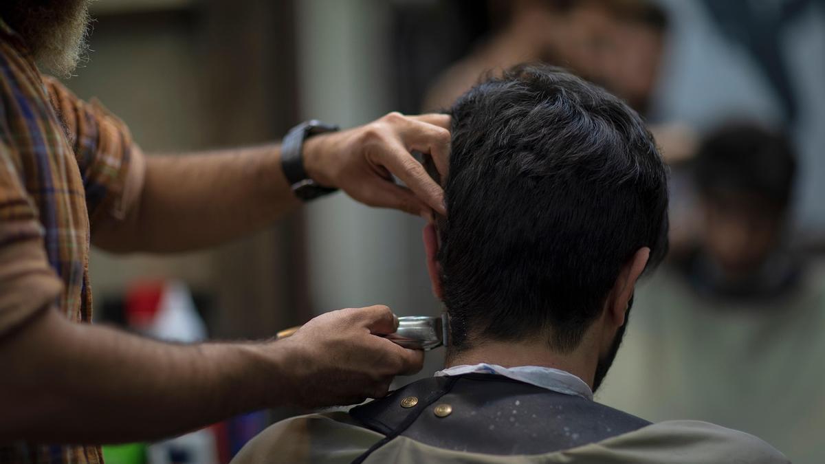 Un joven es atendido en una peluquería
