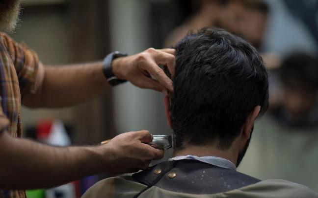 Un joven es atendido en una peluquería