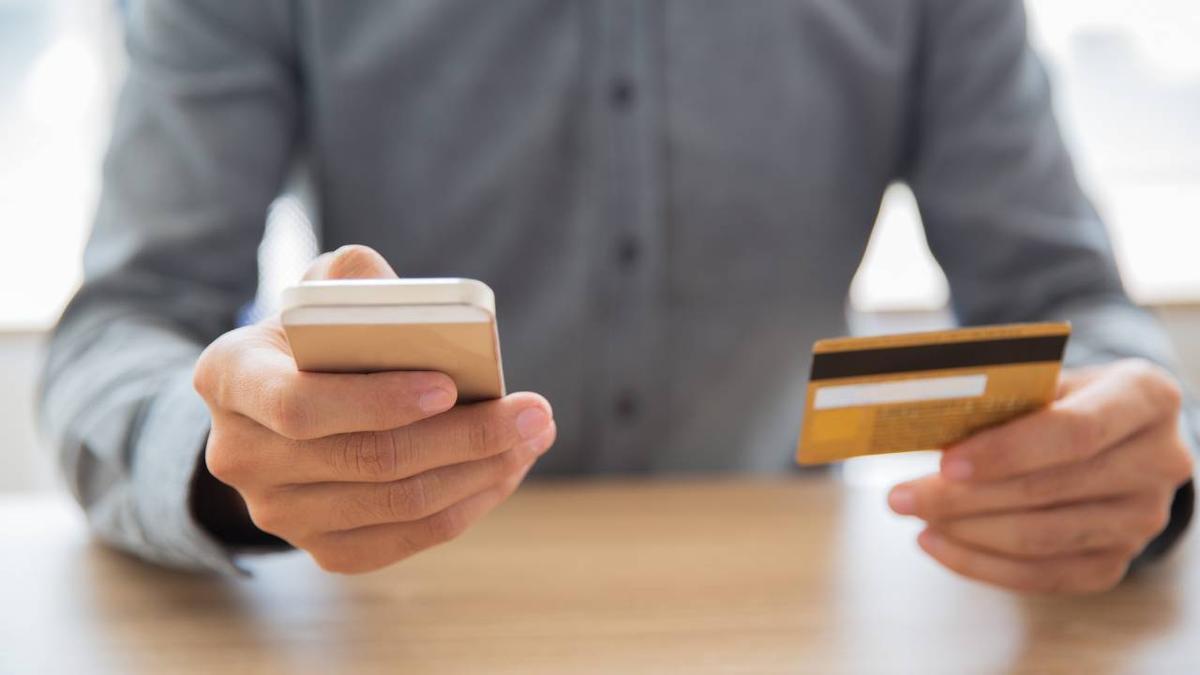 Un adulto realiza una gestión bancaria con el móvil