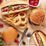 Mesa repleta de comida basura dulce y salada.