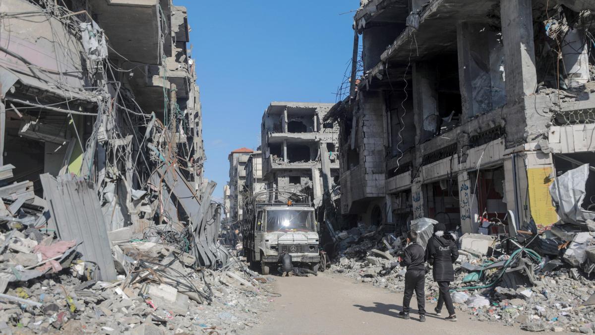 Dos palestinos pasean entre los edificios destruidos por la guerra en Al Nuseirat.