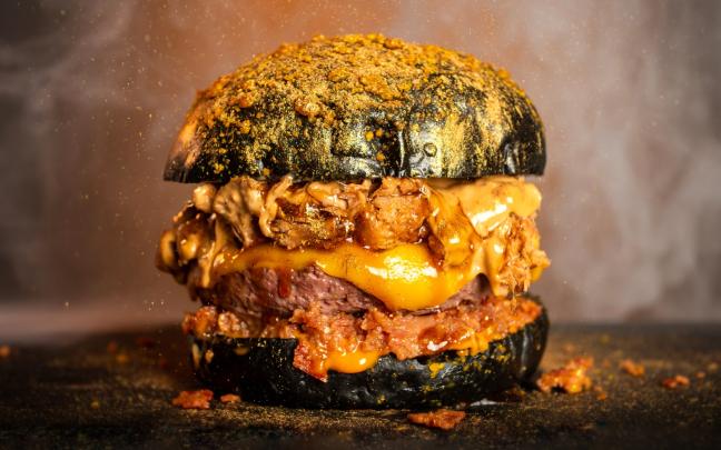 El restaurante cordobés Godeo ha conquistado al público de Barakaldo con su innovadora hamburguesa “Royale Gold”, que se ha alzado como la más votada en The Champions Burger. En su segunda visita a la ciudad, el festival ha registrado un rotundo éxito de asistencia, reuniendo a más de 100.000 personas y consolidándose como uno de los certámenes gastronómicos más destacados del año. Esta burger también ha ganado en Madrid, Cádiz, Valladolid, Santander, Vitoria-Gasteiz y León, y ha sido de las mejor valoradas en Gijón, Logroño, Badajoz, Valencia y Donostia. La “Royale Gold” se ha alzado con la victoria por su receta innovadora con pan brioche cubierto de oro comestible, mermelada de beicon, carne de chuletón, queso ahumado, costillar de ternera a baja temperatura 48 horas, sour cream ahumada, salsa Emmy y beicon bits. Otra de las creaciones que ha conquistado al público de Barakaldo ha sido la insuperable “Top 1”, del establecimiento malagueño Dak Burger, que ha obtenido la segunda posición gracias a su carne de chuletón premium, black angus deshilachado, chédar rojo madurado, beicon dulce, cebolla crujiente, mayonesa tostada 2.0, polvo lunar y crujiente estelar. Esta hamburguesa se mantiene como una de las más votadas del certamen nacional, logrando situarse entre las tres primeras posiciones en ciudades como Donostia, Vitoria-Gasteiz, Santander y León. El podio lo completa el restaurante murciano Tokio, con su victoriosa “The Winner”, una creación que ha sorprendido por su refinada combinación de pan brioche con reducción de vino tinto, queso gouda ahumado, carne wagyu cocinada durante 48 horas a baja temperatura y caramelizada, crema de queso trufada y cecina crujiente. Esta hamburguesa también ha destacado entre las más valoradas en ciudades como Madrid, Siero (Asturias), Zaragoza, Alicante, Murcia, Cádiz, Valencia y Donostia. Por su parte, Tximist ha recibido el reconocimiento de su público más cercano al alzarse con la categoría de “Favorito local” gracias a la majestuosa “The Queen”. Una receta sofisticada elaborada con pan brioche negro con oro, chuletón smasheado, chédar americano, trufa de crema de queso, costilla a baja temperatura durante 24 horas, crujiente premium, salsa The Queen y lluvia de oro. Estas elaboraciones se han convertido en las favoritas del público de Barakaldo, que durante doce días ha votado por sus propuestas preferidas valorando aspectos como el pan, la carne, la originalidad, la combinación de ingredientes y la presentación. Actualmente, la ruta de The Champions Burger continúa en Benidorm, hasta el próximo 17 de agosto, y en A Coruña, que se incorpora por segundo año consecutivo al circuito, del 13 al 24 de agosto. Las próximas ciudades se anunciarán de forma progresiva. Más novedades en 2025: récord de ciudades con más de 50 paradas The Champions Burger está recorriendo más de 50 ciudades entre febrero y diciembre, tras el éxito de la edición anterior, que superó los cuatro millones de visitantes y participaron más de 100 hamburgueserías. La ruta 2025 está visitando nuevas localidades para responder a la gran demanda del público. El ganador se conocerá a finales de año La final de la “Mejor hamburguesa” se celebrará a finales de año, tras una intensa competición. Será en la última ciudad donde se conocerán las 35 hamburgueserías que lucharán por el título nacional. El festival también buscará la “Mejor hamburguesa de Europa”, consolidando su carácter internacional. En esta competición participarán las mejores hamburgueserías del año junto a una selección de propuestas de alto nivel procedentes de diversos países europeos.