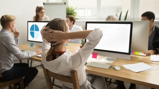 businesswoman holding hands head resting finishing work rear view
