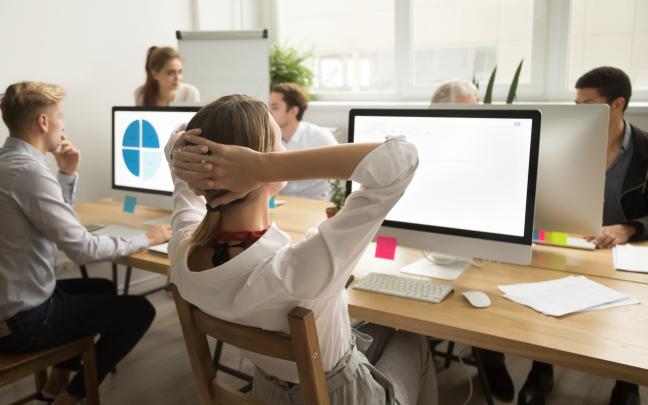 businesswoman holding hands head resting finishing work rear view