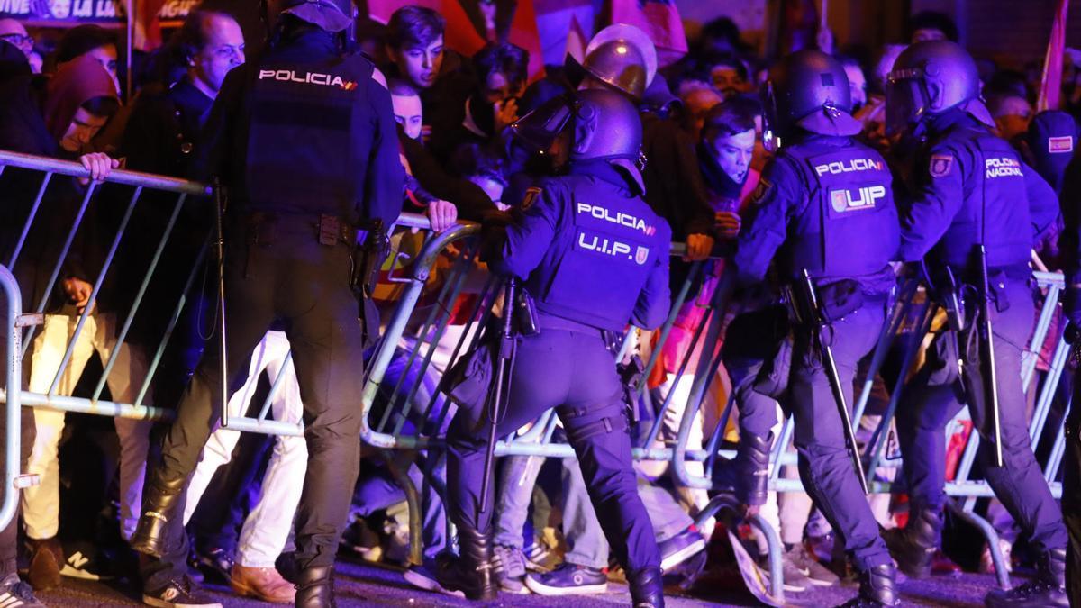 Agentes antidisturbios intentan contener a manifestantes ante la sede socialista de Ferraz
