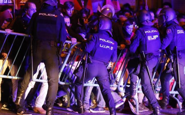 Agentes antidisturbios intentan contener a manifestantes ante la sede socialista de Ferraz