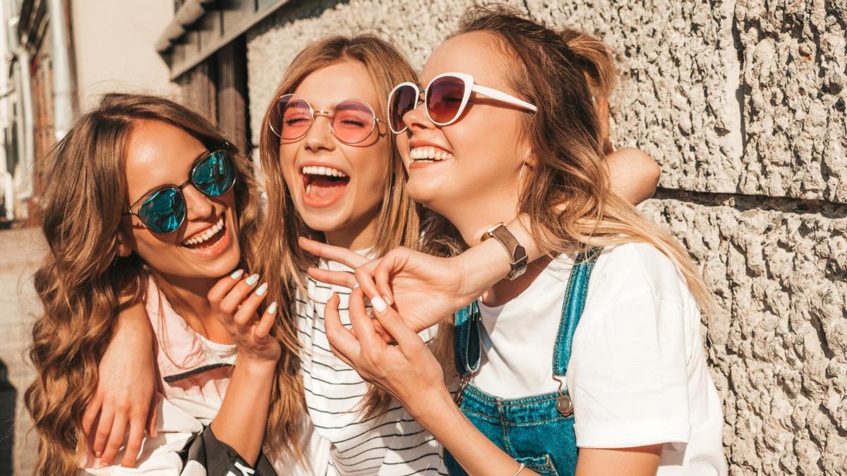 Tres jóvenes amigas ríen y se divierten mientras disfrutan de un rato juntas.