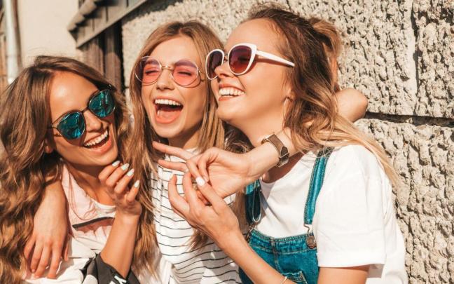 Tres jóvenes amigas ríen y se divierten mientras disfrutan de un rato juntas.