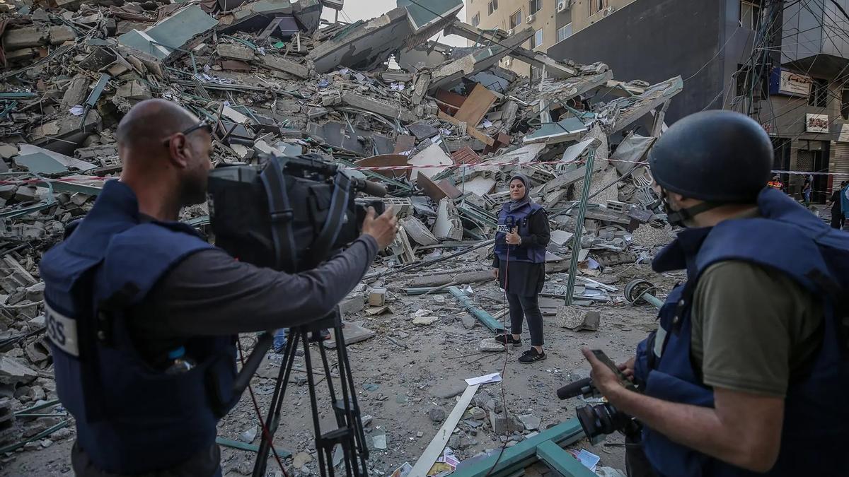 Un equipo de reporteros trabajan junto a unas ruinas en Gaza