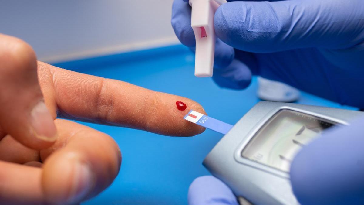 Un sanitario realiza un análisis de glucosa a un paciente.