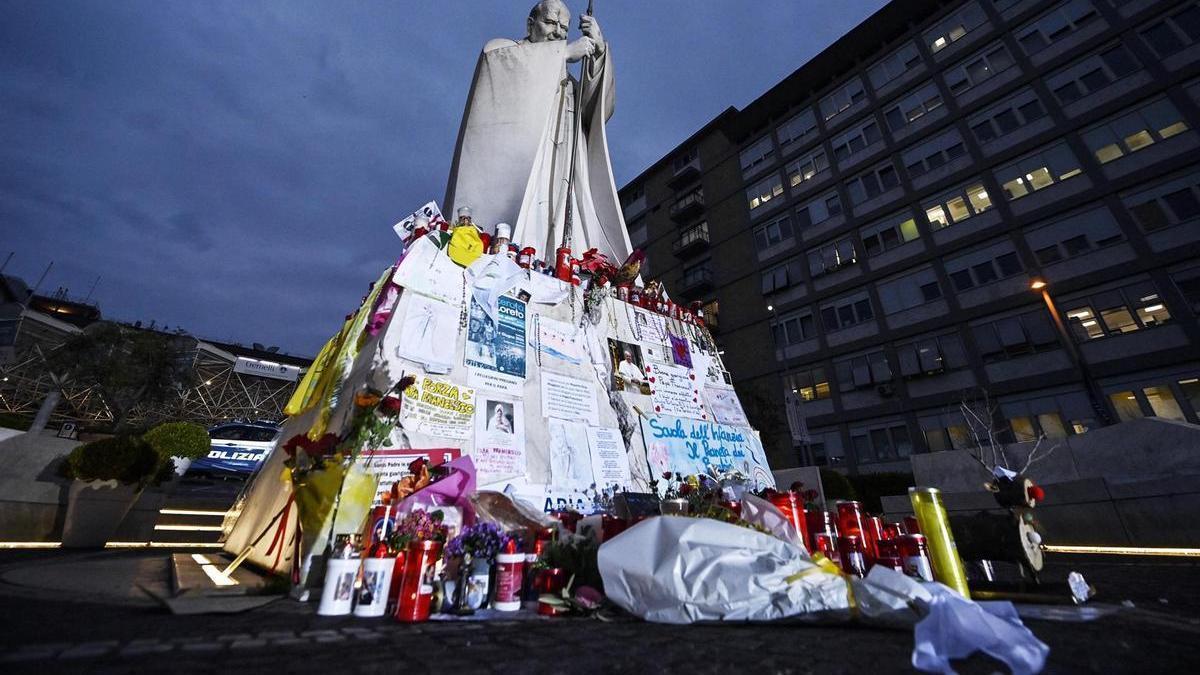 Velas, flores y mensajes de apoyo al papa Francisco a los pies de la estatua de Juan Pablo II en el hospital Gemelli de Roma, donde el pontífice permanece ingresado.