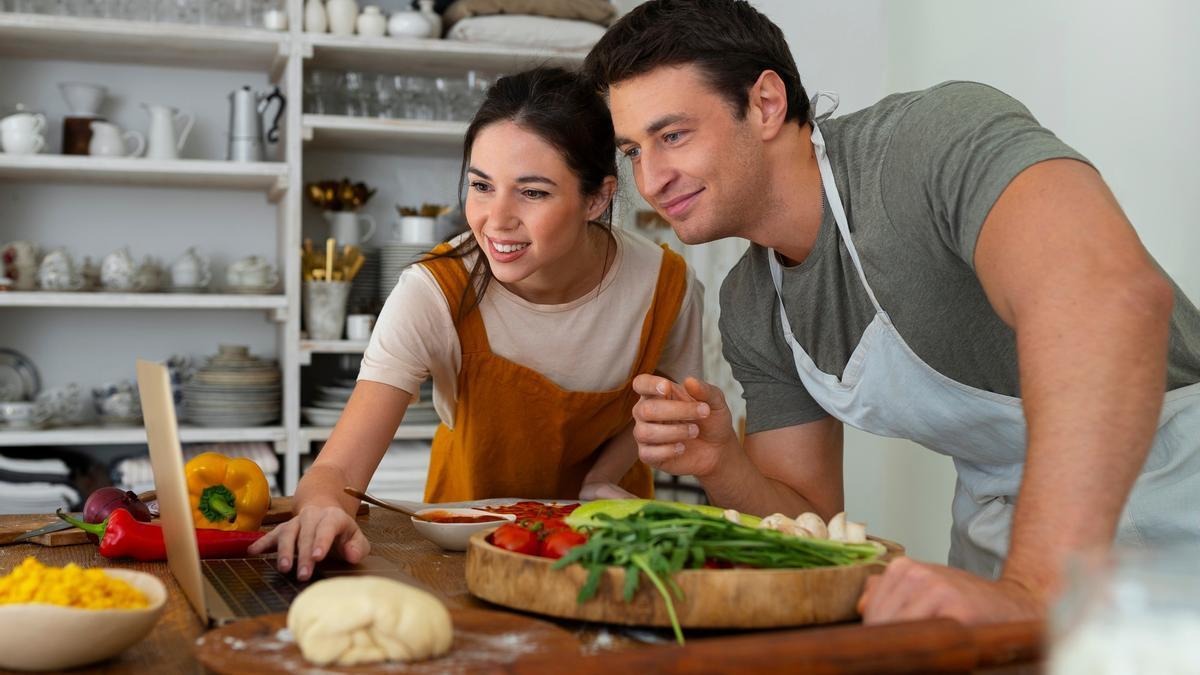Una pareja comparte la preparación de una receta de cocina.