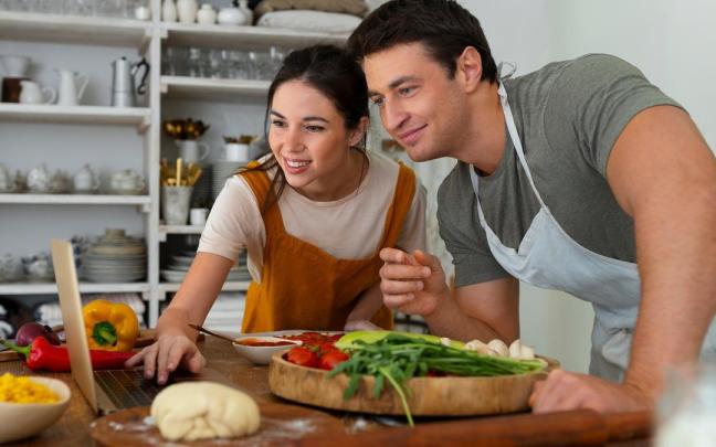 Una pareja comparte la preparación de una receta de cocina.