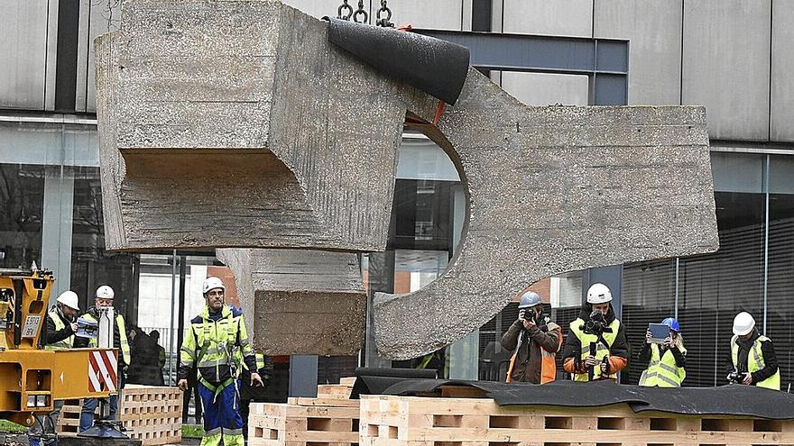 Operarios colocan la escultura de Chillida sobre palets antes de ser trasladada.