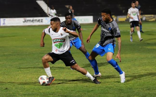 Antonio Otegui se zafa de dos rivales en un lance del partido.