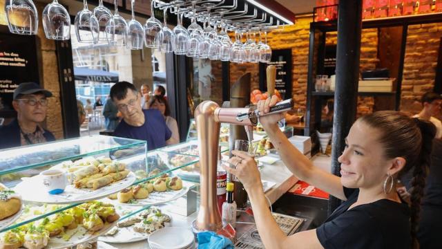Una camarera trabaja tras la barra de un bar en Bilbao.