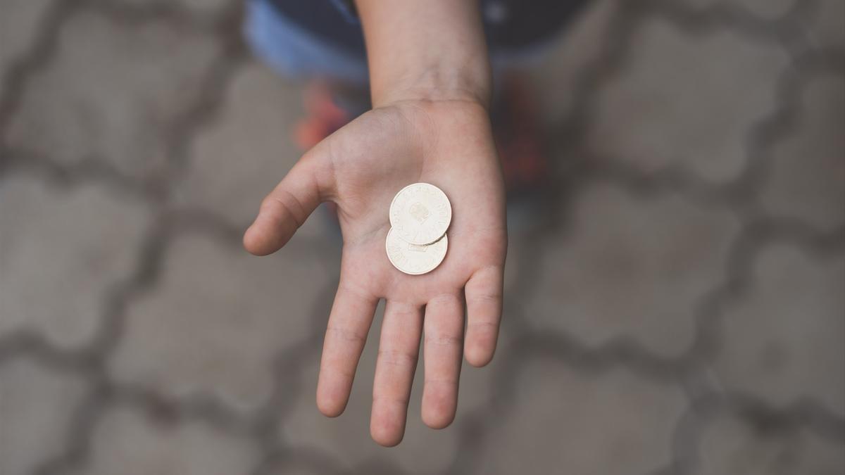 Una persona con monedas en la mano