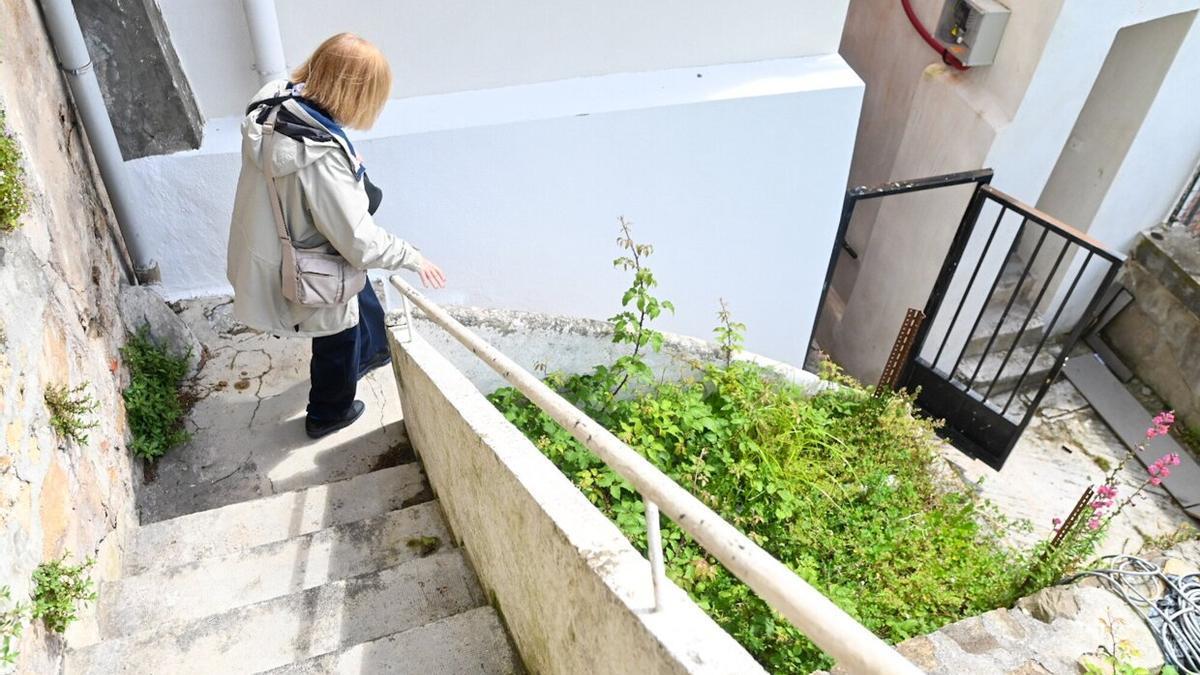 Una mujer baja por las escaleras que conectan las viviendas con el muelle.