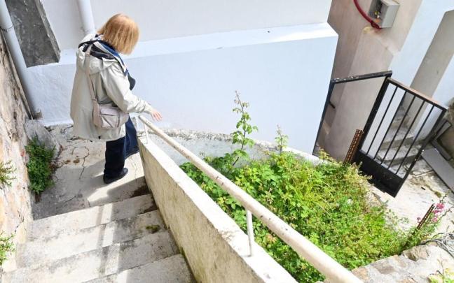 Una mujer baja por las escaleras que conectan las viviendas con el muelle.