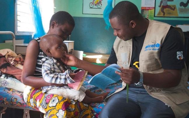 Un voluntario de UNICEF atendiendo a un niño en una foto de archivo. Un voluntario de UNICEF atendiendo a un niño en una foto de archivo.