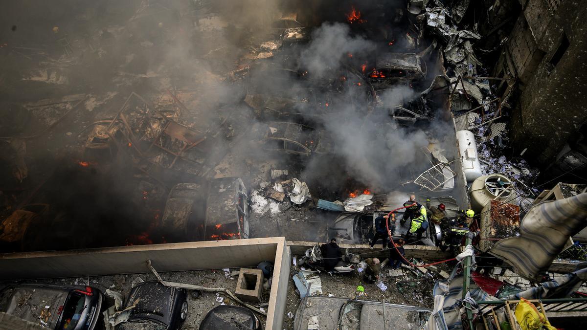 Los bomberos extinguen un incendio en un lugar afectado por un ataque aéreo israelí en Beirut.