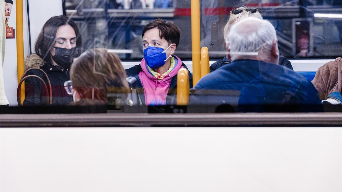 Varias personas con mascarilla en un tren.