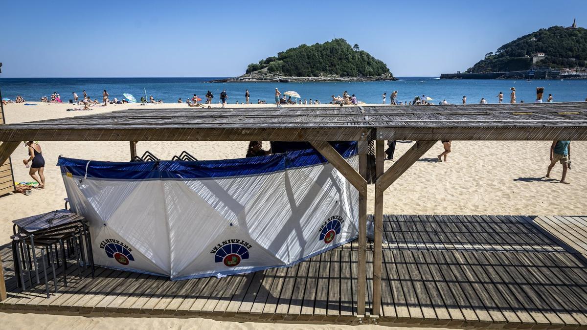 La Ertzaintza acordona con un biombo el cuerpo del hombre fallecido en la playa de Ondarreta / Javier Etxezarreta