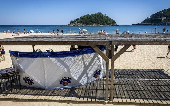 La Ertzaintza acordona con un biombo el cuerpo del hombre fallecido en la playa de Ondarreta / Javier Etxezarreta