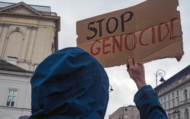 Una persona sostiene un cartel que pide parar el genocidio en Gaza durante una protesta a favor de Palestina en Varsovia.