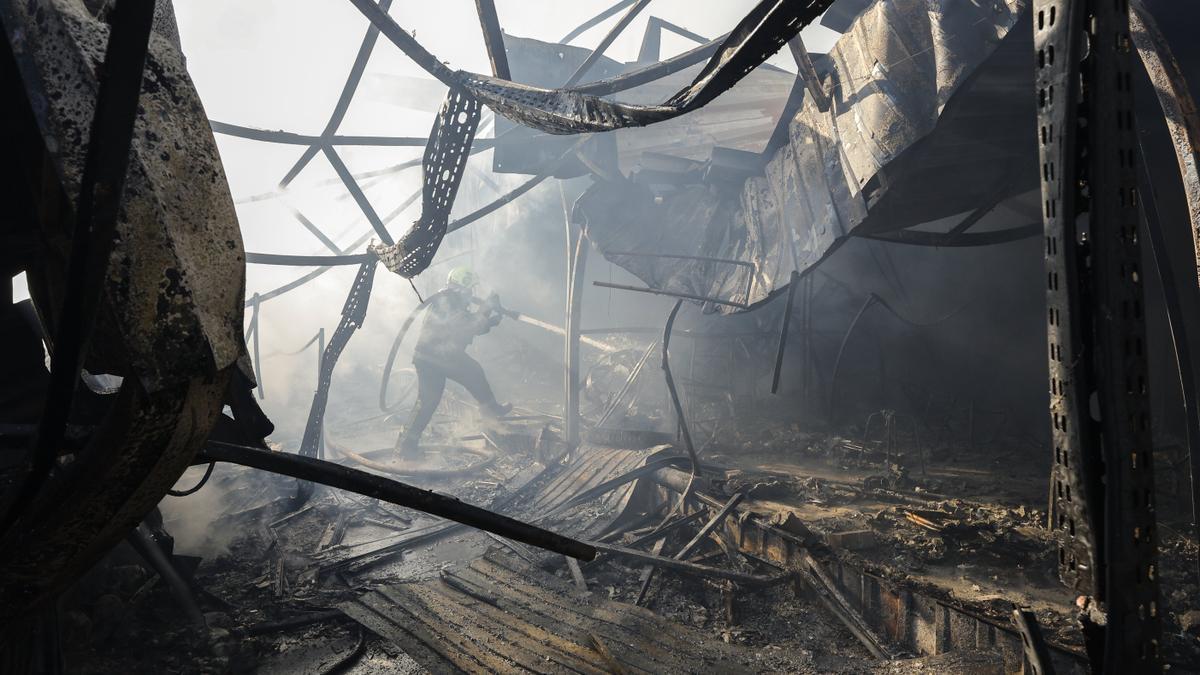 Los equipos de rescate ucranianos trabajan en el lugar donde un misil ruso ha impactado en un mercado de Kiev.
