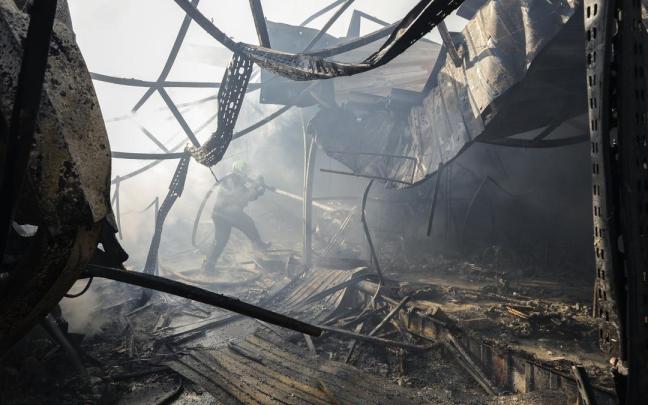 Los equipos de rescate ucranianos trabajan en el lugar donde un misil ruso ha impactado en un mercado de Kiev.