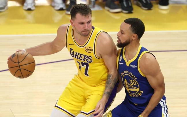 Luka Doncic dirige el balón ante Stephen Curry en el estreno de la temporada de la NBA.