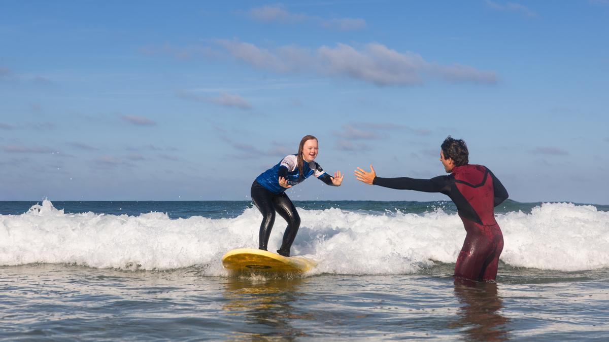 Una participante del programa de la ONG Koaina durante una sesión de surf therapy en el agua.