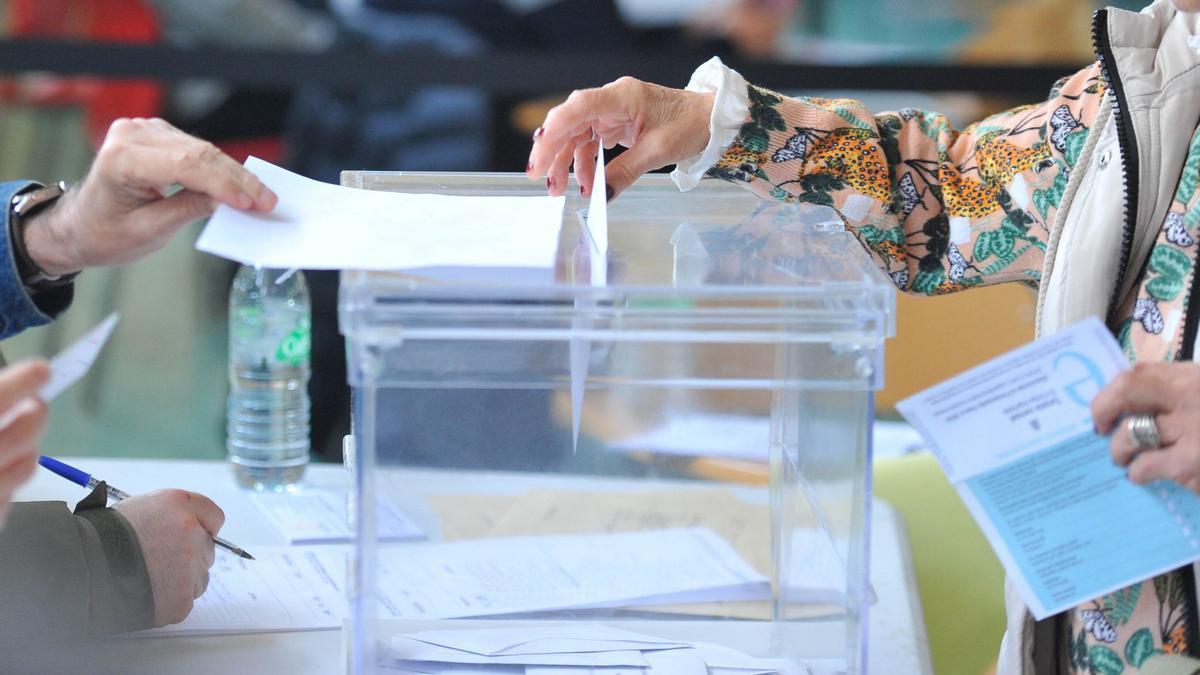 Una mujer deposita su voto en un colegio electoral.