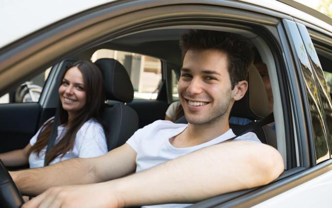 Dos jóvenes, dentro de un coche.