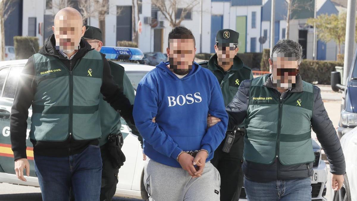 Agentes de la Guardia Civil trasladan al detenido por la presunta implicación en la muerte de su novia en Sevilla.