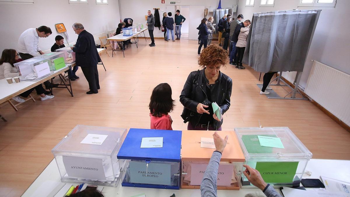 Una mujer se dispone a votar en un colegio con urna a las elecciones al concejo en la Cendea de Zizur.