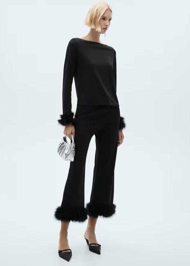 Conjunto monocromático negro con top y pantalón crop con plumas.