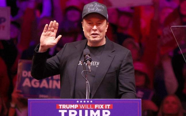 Elon Musk saluda al público durante un mitin de campaña de Trump.