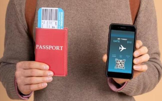 Un hombre sostiene un pasaporte y una tarjeta de embarque digital