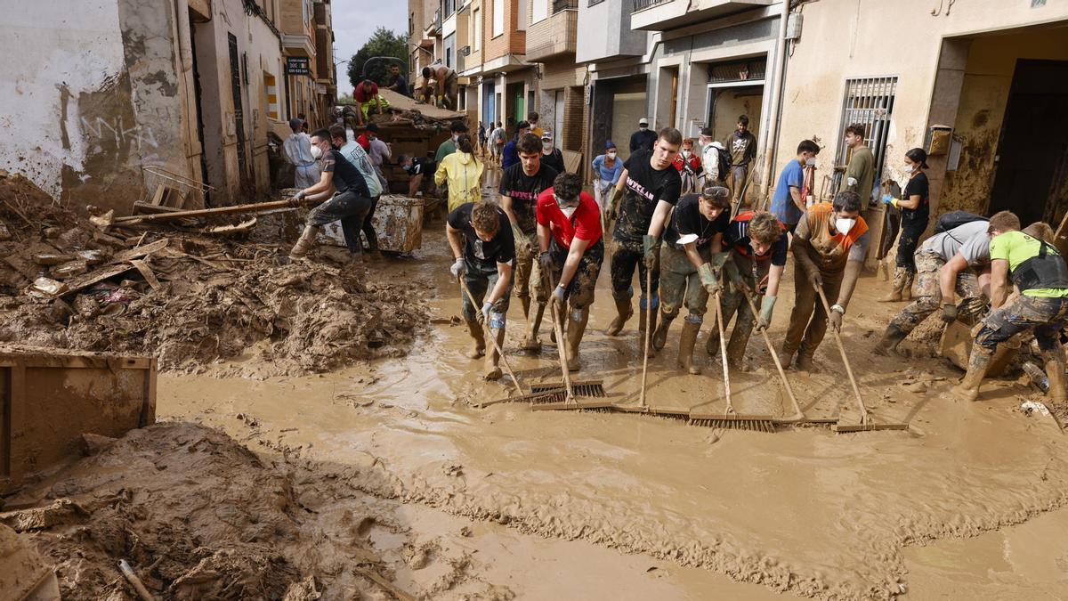 Un equipo de voluntarios limpia las calles de una localidad afectada por la DANA.