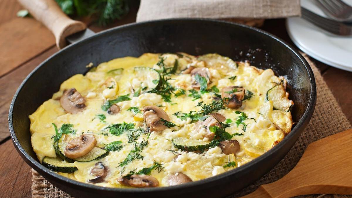 Tortilla francesa con espinacas, calabacín y champiñones en la sartén