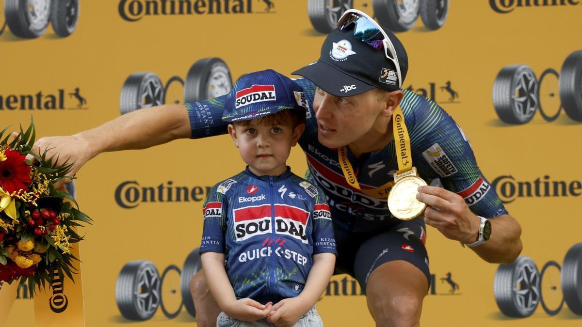 Merlier festeja con su hijo la victoria en el podio.