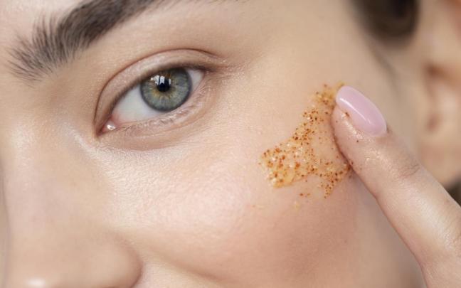 Una mujer aplicándose microperlas exfoliantes.